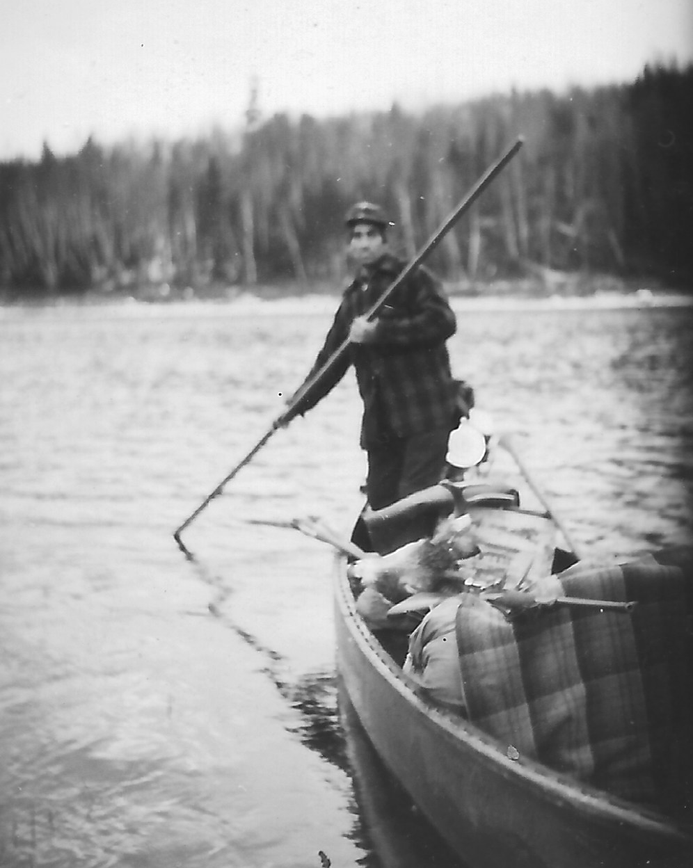 A canoeist poling along the Allagash River in Maine's North Woods, the same wilderness waterway system where the Allagash Four camped and fished in August 1976.